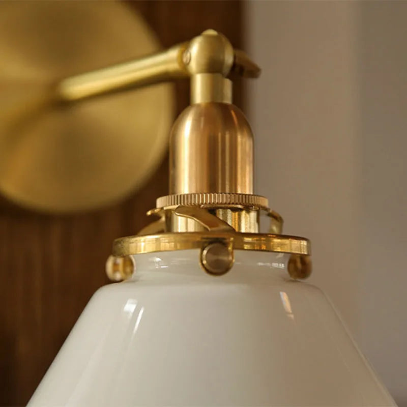 Close-up of a white lampshade with gold fixture against a blurred background