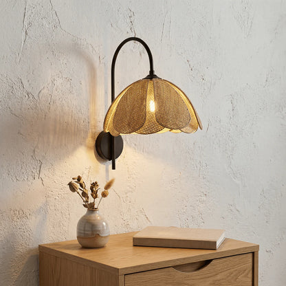 Artisan rattan curved wall light providing eco-conscious natural bedroom lighting