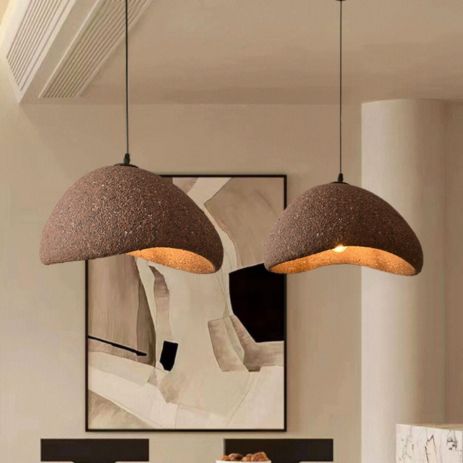 Artistic pebble-shaped pendant fixture with earthy texture and warm light
