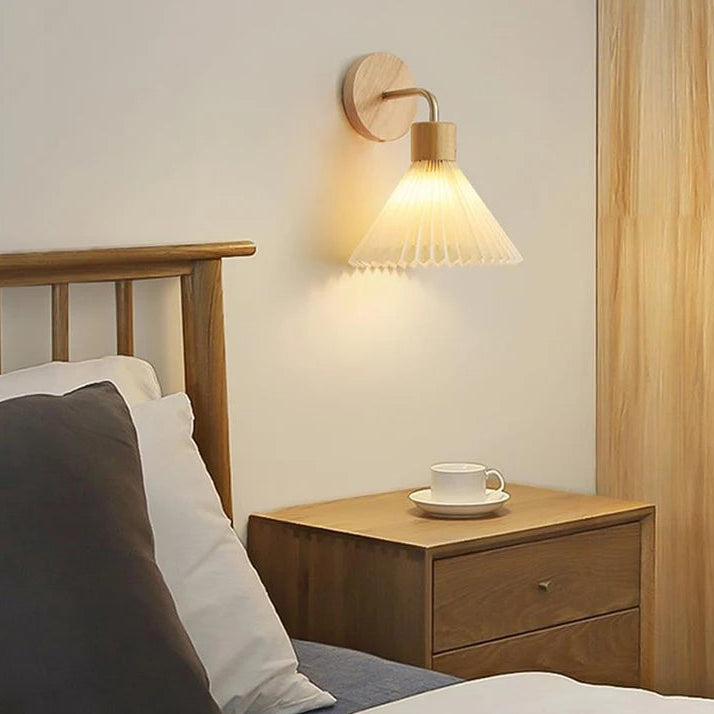 Bedroom interior with wooden headboard, nightstand, and wall lamp.