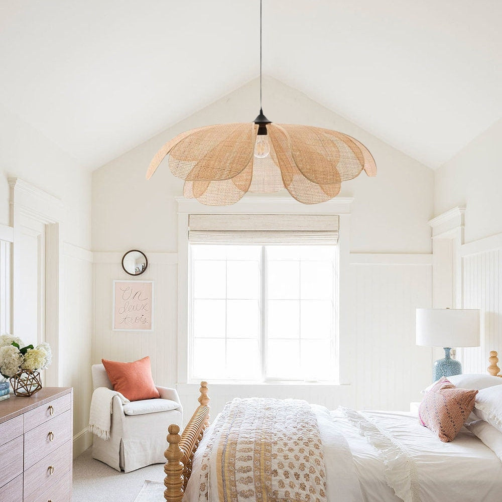 A blooming rattan flower petal pendant light glowing warmly in a serene Japandi living room corner above a cream accent chair.