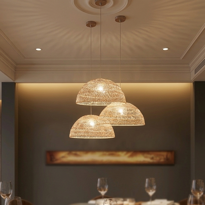 Cascading rattan and wicker pendant shades with internally exposed glowing light bulbs in a neutral-toned room.