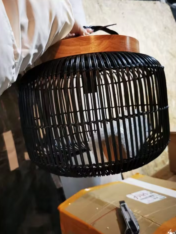 Vintage style bamboo cylinder chandelier set suspended near old weathered wooden shutters.