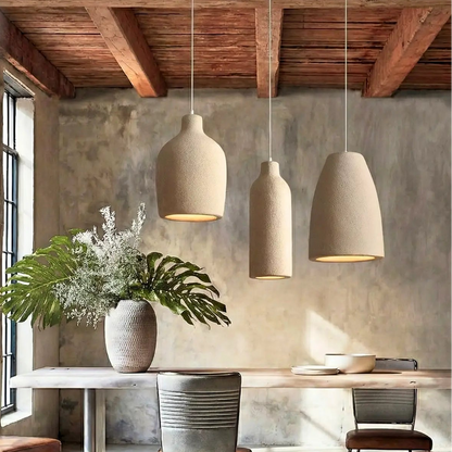 Trio of textured clay hanging lamps casting warm light over a modern cream sofa.