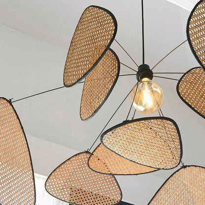 Abstract floating wicker chandelier with delicately suspended rattan mesh panels mimicking wind-blown leaves.