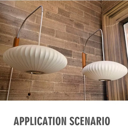 Two modern wall-mounted pendant lights with ribbed white shades and curved metal arms, shown against a brown brick wall with the text 'APPLICATION SCENARIO' below.