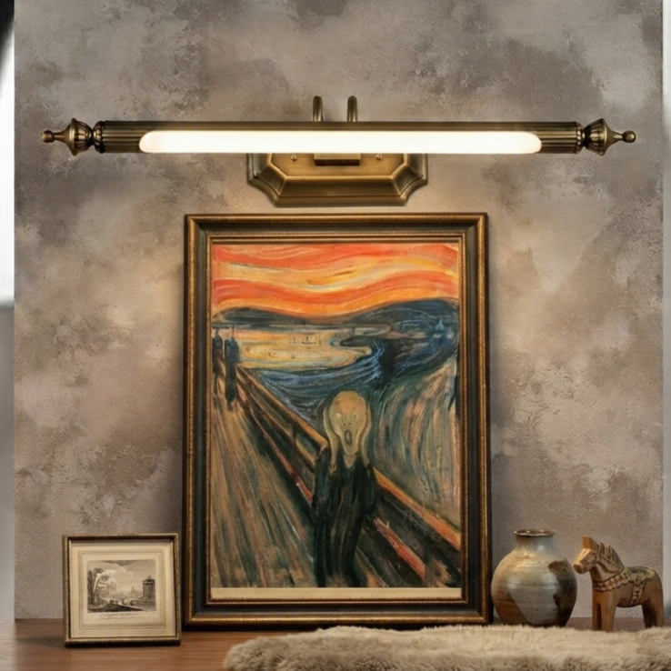 A vintage-style wall sconce light fixture with a horizontal bar and brass-toned details, mounted above a framed Edvard Munch painting of The Scream in a rustic room setting.