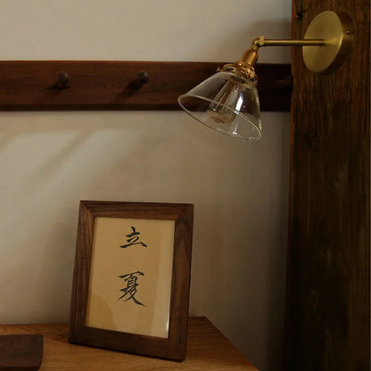 Wall-mounted lamp with a wooden frame and text on a shelf.
