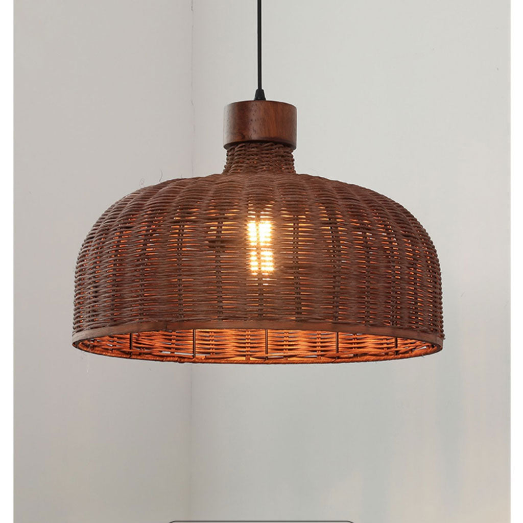Minimalist rattan drum hanging lamp suspended by a sleek black cord with a luxurious brass and wood canopy detail.