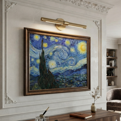 A framed Van Gogh-style wall art print depicting a swirling blue and yellow night sky over a dark cypress tree and village, hung on a white decorative wall above a wooden console in a styled interior room.