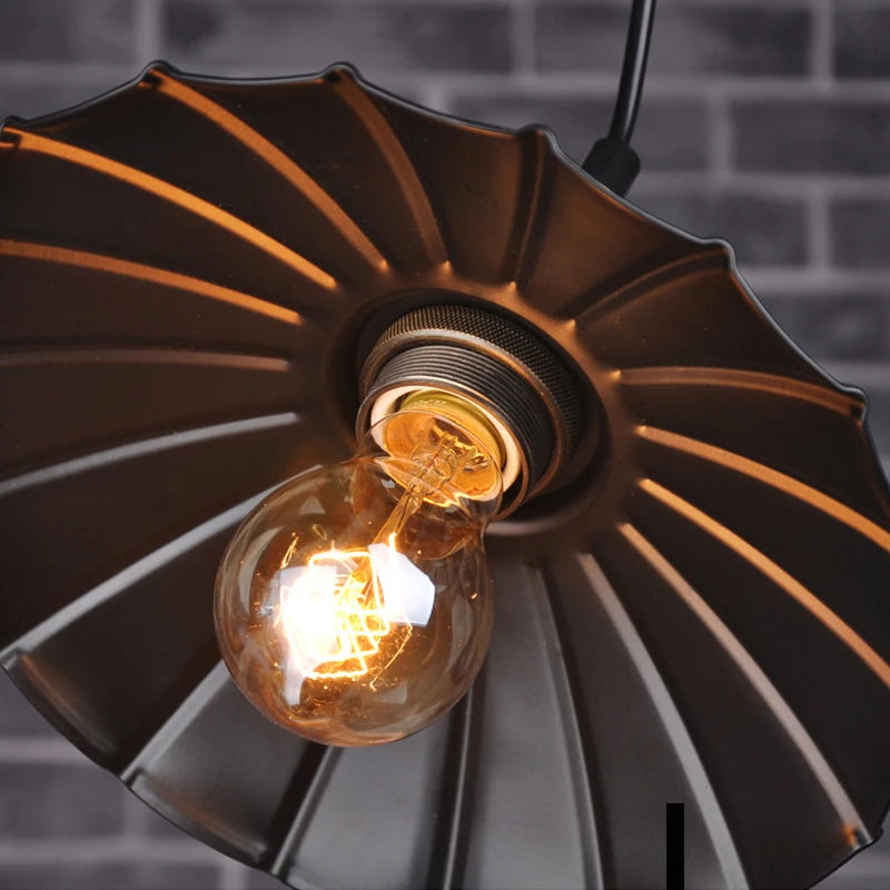 Vintage-style light fixture with a glowing bulb against a dark brick wall.