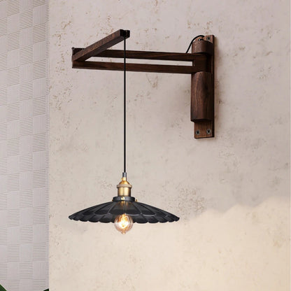 Wall-mounted industrial-style pendant light with wooden bracket and black glass shade.
