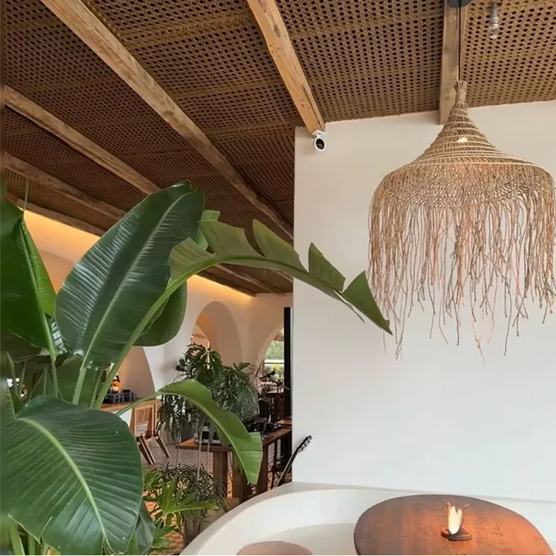 A beautiful hand-woven fringe pendant light creating a relaxing, luxury atmosphere at a tropical beachfront resort.