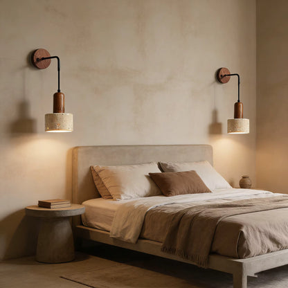 Bedroom with a bed, side table, and wall sconces on a beige wall.