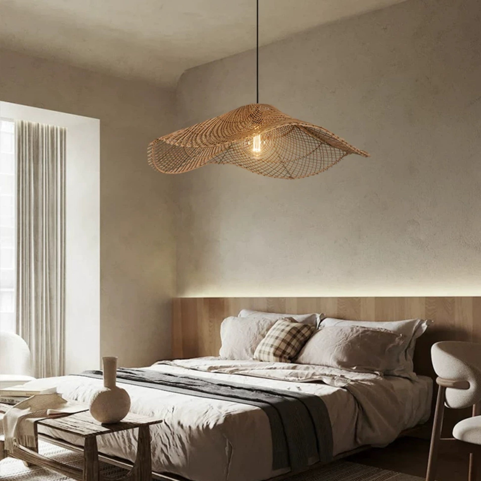Two wavy rattan mesh pendant lights hanging linearly above a long wooden dining table set with modern cane chairs.