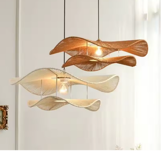 Wavy rattan pendant light in an artistic dual-layer wave shape illuminating a cozy Wabi-sabi living room with low sofa seating.