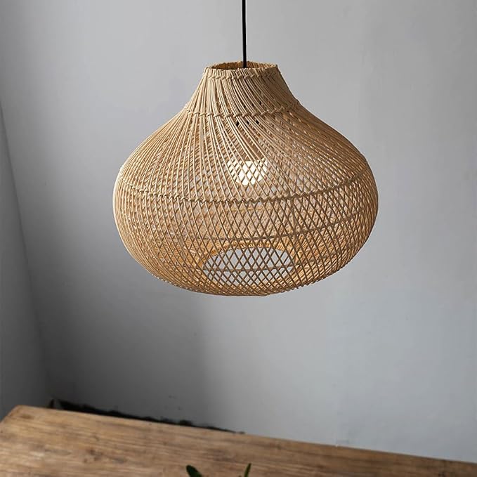 Close-up view of two large, intricate teardrop-shaped wicker lamp shades on dinning table