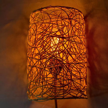 Neoclassical natural rattan wall sconce blending intricate tangled textures with elegant architectural living room decor.