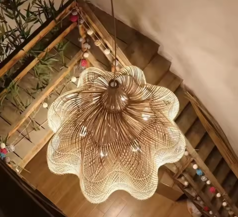 Scalloped rattan flower petal pendant light hanging in a Zen dining room above a rustic wooden table with a mini fireplace
