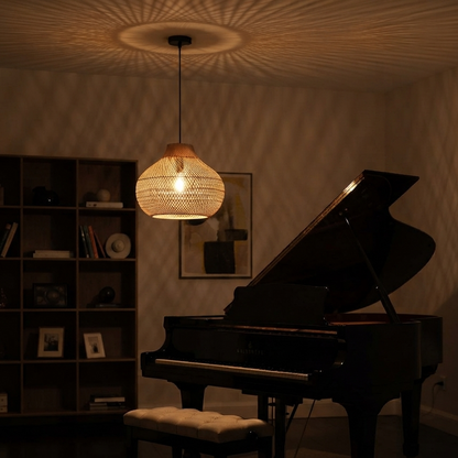 A beautiful rattan pendant light hanging above a black grand piano in a cozy, dimly lit room with warm ambient lighting.