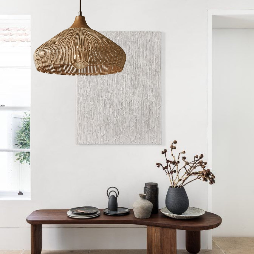 A rustic wicker pendant light suspended over a wooden dining table area.