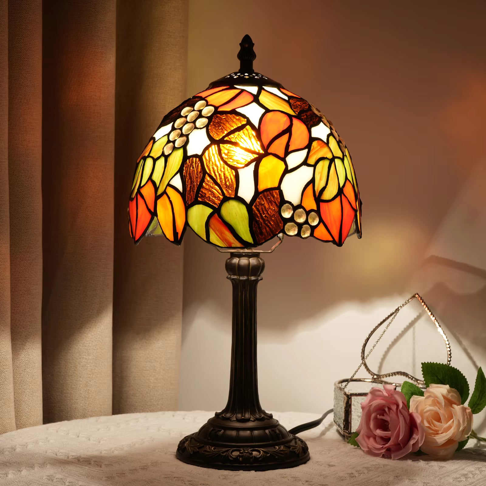 Stunning Tiffany-style stained glass table lamp featuring a vibrant grape cluster design, providing warm ambient lighting for living rooms.